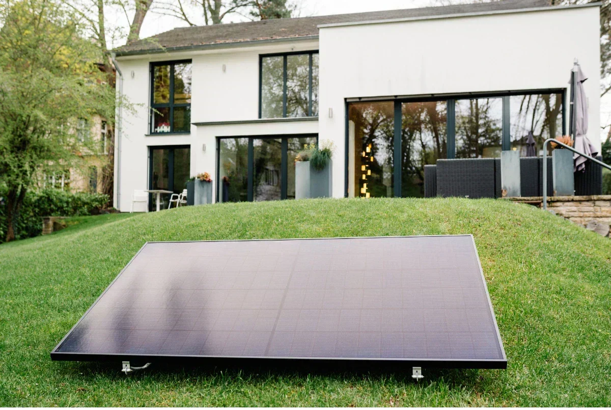 Solarmodul auf dem Rasen vor einem Haus
