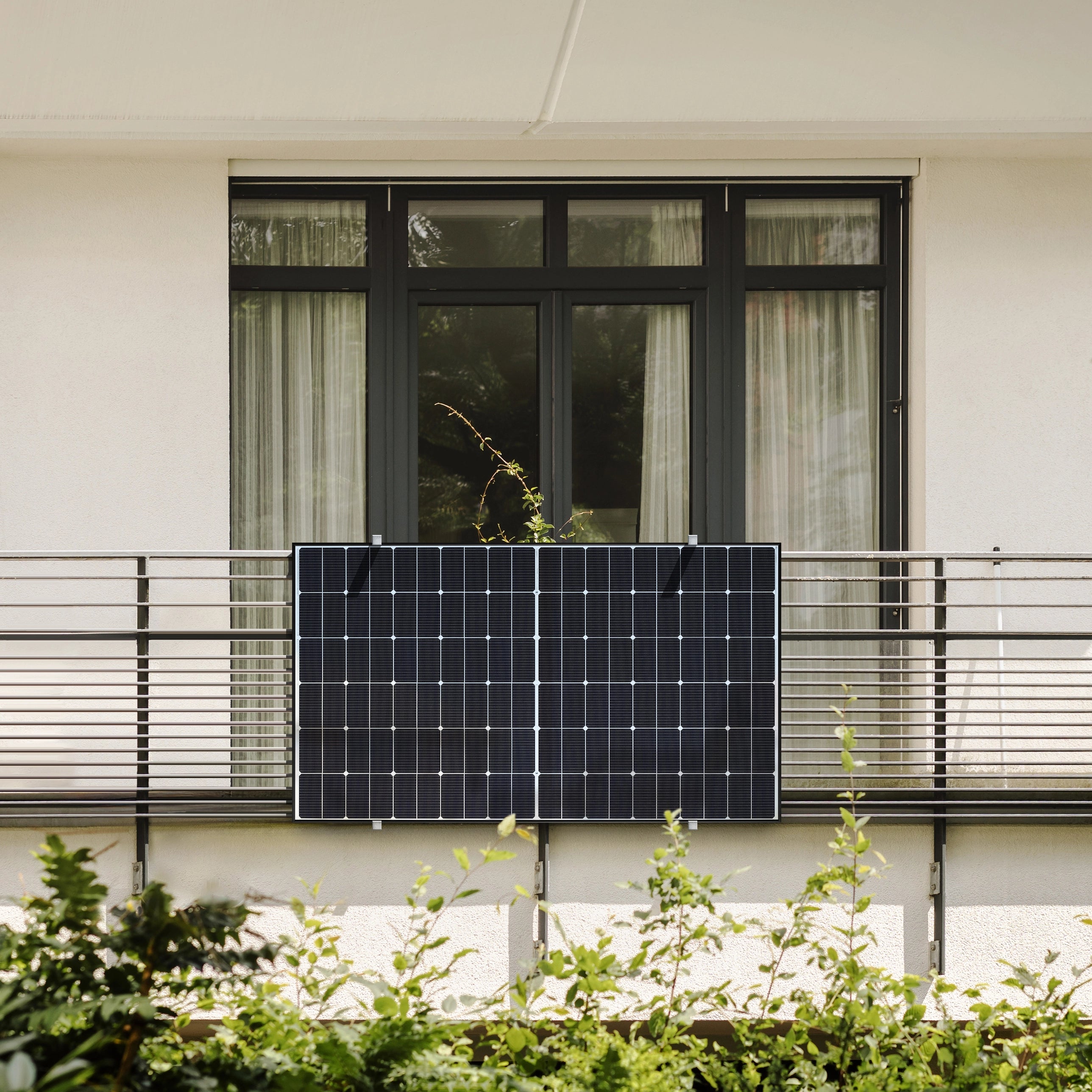 Balkonkraftwerk am Balkon mit Balkontür und weißer Wand im Hintergrund