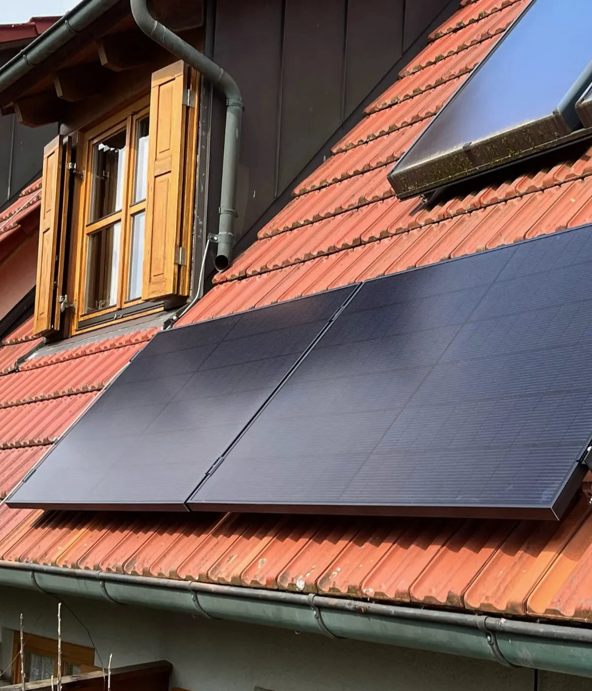 Zwei Solarmodule am Ziegeldach bei Sonnenschein