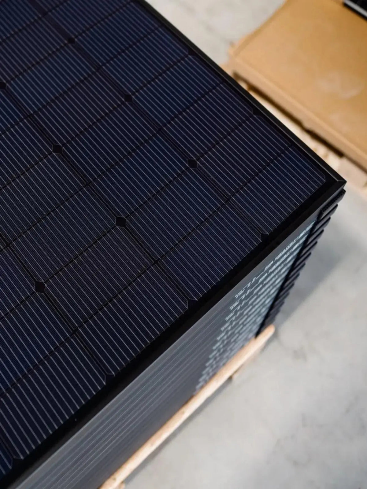 mehrere full black Solarmodule aufeinander gestapelt im Lager